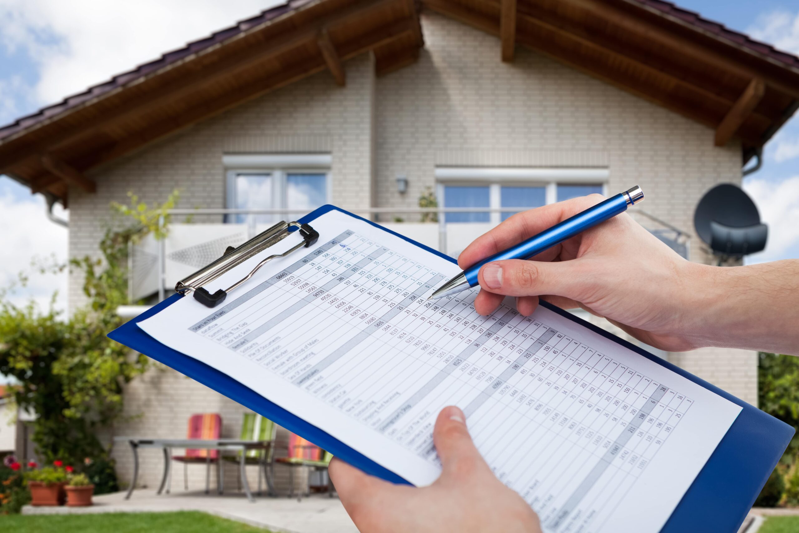 appraiser in front of a house with clipboard in hand